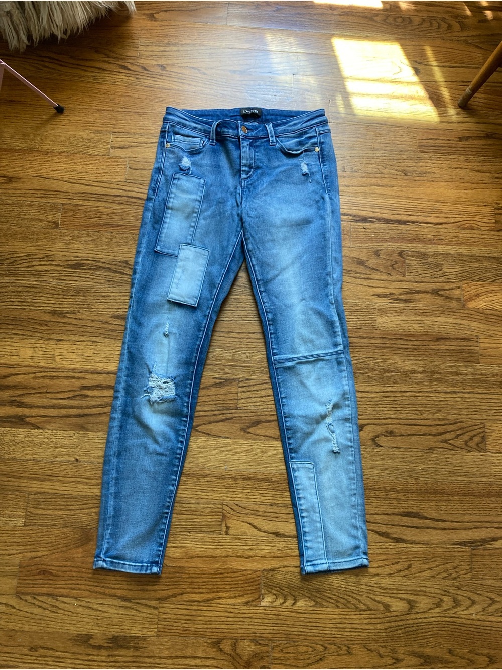 Bebe blue denim jeans with distressed patches and ripped details, size 27